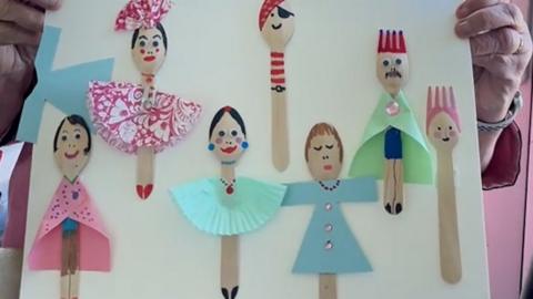 Paper Spoons and forks made to look like people with facial features and paper clothes stuck on.