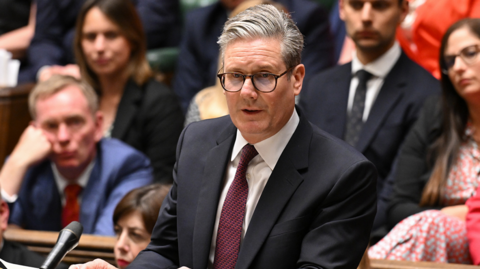 Keir Starmer in a dark suit and burgundy tie speaks in the Commons