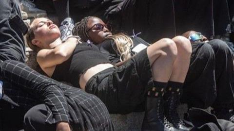 Students, dressed in black, are seen lying down as they take part in a silent protest in South Africa