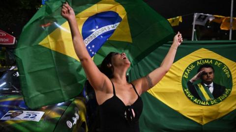 A supporter of Brazilian President and re-election candidate Jair Bolsonaro reacts as she watches the vote count of the legislative and presidential election, in Rio de Janeiro, Brazil