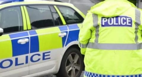 Police car and back of police officer's jacket