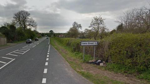 A stretch of the A48 with the signposted turning for Oakle Street in Minsterworth