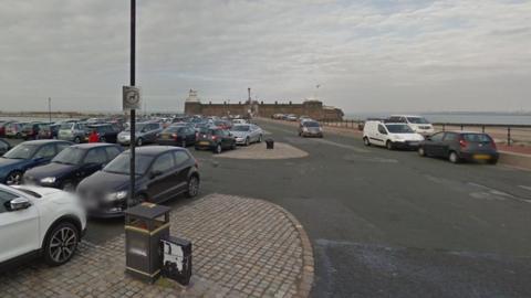 Cars parked in the Fort Perch Rock Car Park, with the River Mersey and Fort Perch Rock seen in the background.