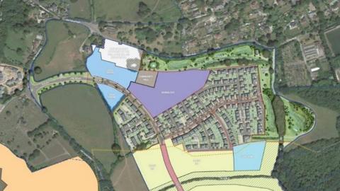 Plan shows the plans for Wolborough Barton with the aerial view image showing a housing estate situated just off the main link road. In different colours are areas marked school site and care home.