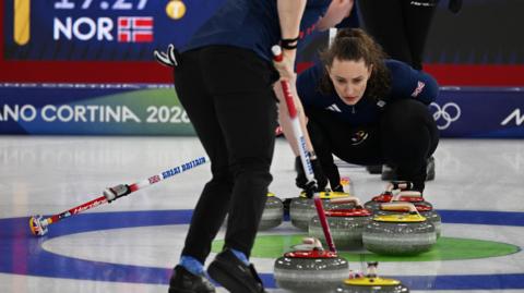 Jennifer Dodds curls the s tone past Britain's Bruce Mouat as they compete in the curling mixed doubles round robin between Britain and Norway 