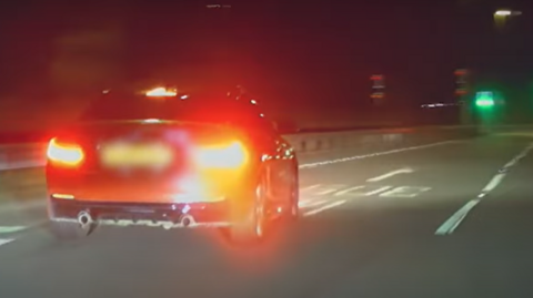 Police dashcam photo of an orange BMW driving anti-socially on a road