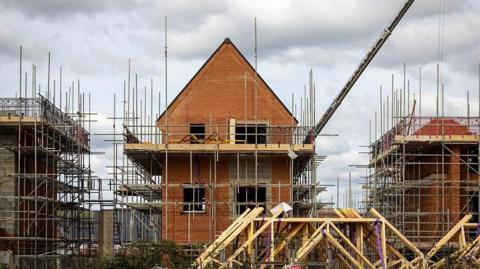 Houses being built. There is scaffolding around three houses.