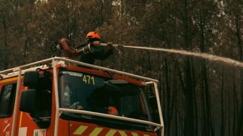 A firefighting crew is deployed to battle a wildfire in Saint-Jean-d'Illac, southwestern France.