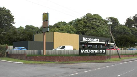 A computer-generated image showing an artist's impression of a McDonald's next to a main road