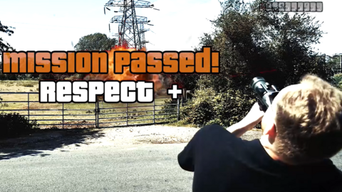 In the middle of the image we can see the words 'mission passed! Respect +' - in the Grand Theft Auto font. Behind we can see a computer generated explosion at the bottom of a pylon in the countryside. In the bottom left of the picture, we can see the back of a man who is aiming a toy weapon at the pylon.
