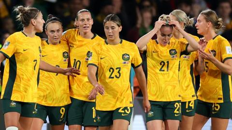 Australia players celebrate their opening goal against Denmark
