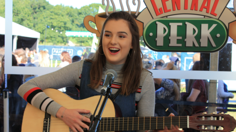 Beth Langton holding a guitar at the Friends TV show experience 