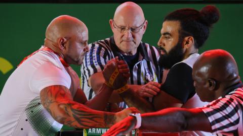 South Africa's James Kruger (left) competes against Egypt's Mustafa Mohamed (right) in the senior men's left arm wrestling competition during the 2023 African Games in Accra, Ghana.