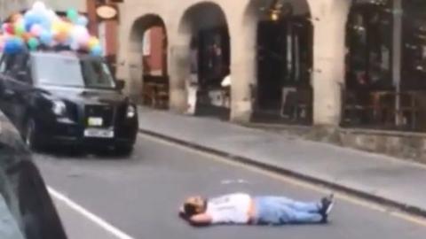 Man on road in front of taxi parade