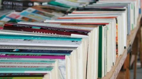 A generic photograph of books lined up in a row on a  table