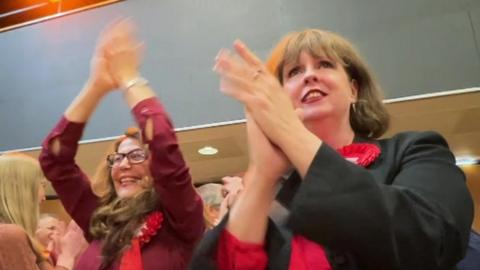 Two Labour supporters clap and cheer