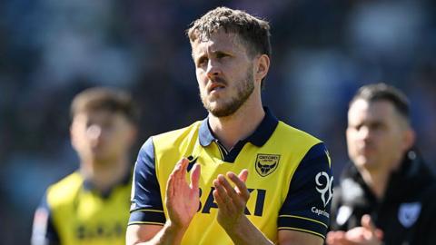 Will Vaulks applauding in an Oxford shirt