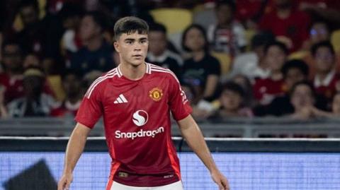 Harry Amass has made seven first team appearances for Manchester United. Here he stands, wearing the club's red shirt, waiting for the ball in a fixture.