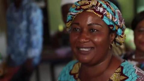 Nigerian woman with blue head dress smiling