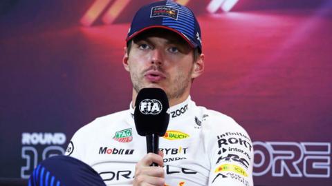 Max Verstappen speaks into a FIA-branded microphone during a Singapore Grand Prix news conference