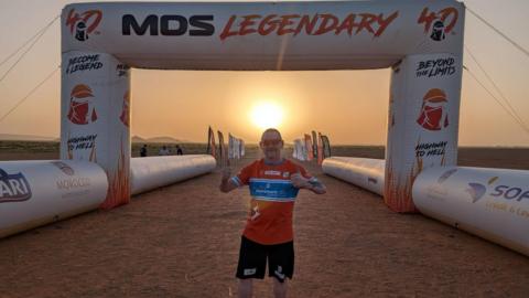 A man in a red top at the start line of Marathon des Sables in Morocco