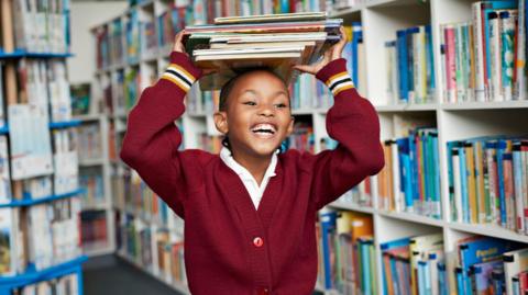 A schoolgirl balancing books on her head