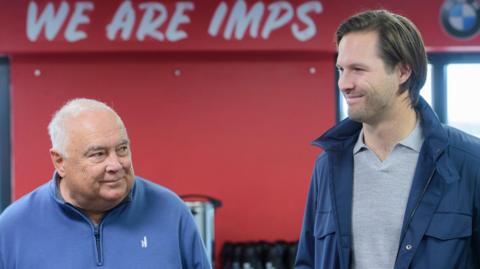 Ron and Andrew Fowler at Lincoln City before their new investment was confirmed