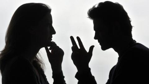 Two people arguing in silhouette