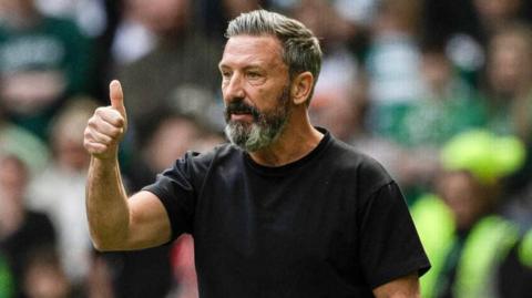 Hearts head coach Derek McInnes gives a thumbs up while standing on the touchline