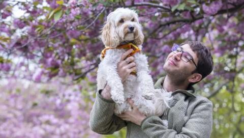 A person holding a dog up in the air