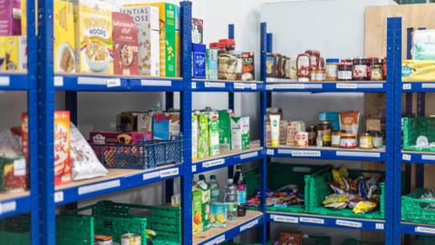 Shelves at Horsham Matters foodbank which have milk, cereal, squash, crisps and porridge on