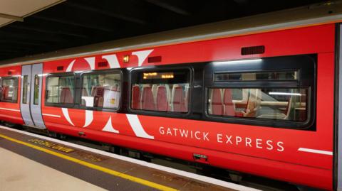A bright red train at a station. 