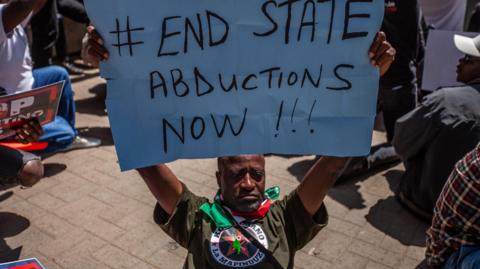 A man holds a banner reading "End State Abductions in Kenya now!" during a protest in the Kenyan capital Nairobi