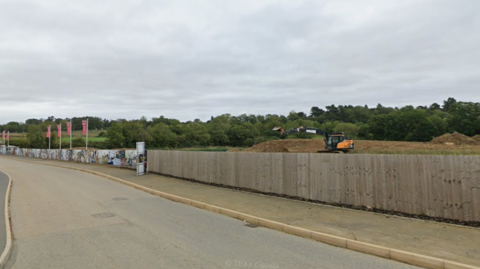 Diggers on the estate, with fencing along the road side