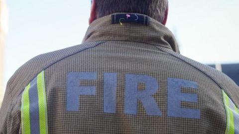 A generic image of the back of a firefighter, with FIRE written on his jacket 