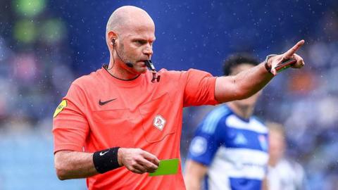 Rob Dieperink holds a yellow card