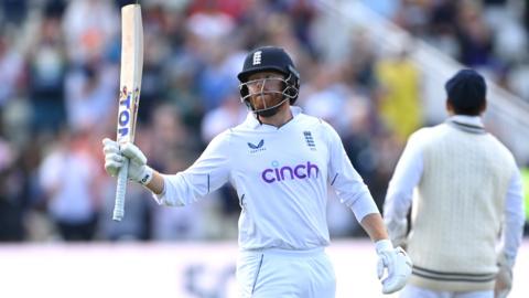 Jonny Bairstow raises his bat to the crowd after reaching 50