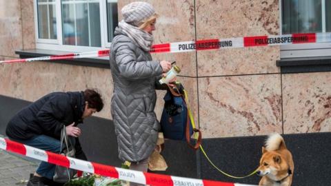 People lay flowers at the scene of the shooting in Hanau