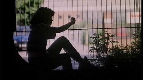 Girl sat by fence