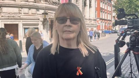 Nicola Jones stood on a London street wearing her Infected Blood victims pin