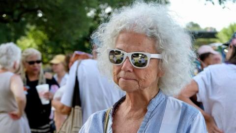 A granny holds a sign saying: 'What wouldn't you do to keep your babies safe?"