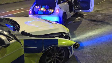 The damaged police car and Audi