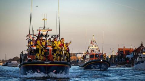 RNLI crew wave to onlookers from on board lifeboats the Doris Mann of Ampthill and the Duke of Edinburgh