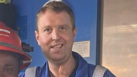 Robert Kincaid wears a blue boiler suit