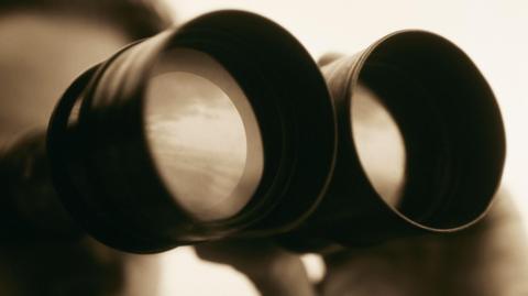 A generic image of someone looking through binoculars. The background is blurred so you can't see who is holding them