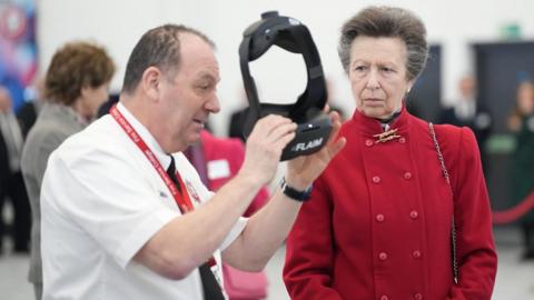 A photo of The Princess Royal observing the use of a virtual reality headset at the Fire Station College