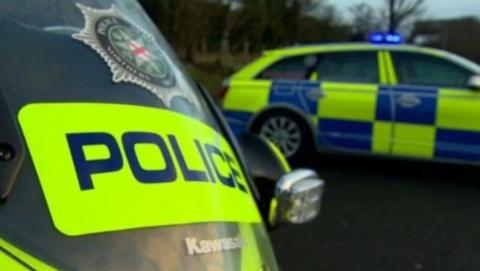 Stationary police vehicles with Police Service emblem