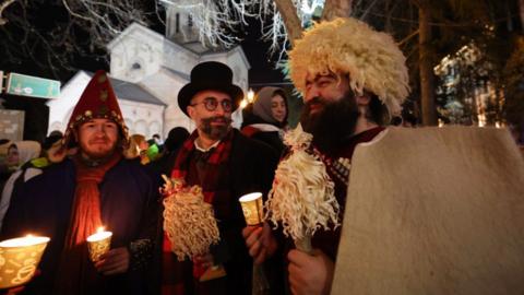 People holding candles gather to celebrate Orthodox Christmas eve along Rustaveli Avenue, in central Tbilisi on January 6, 2025.