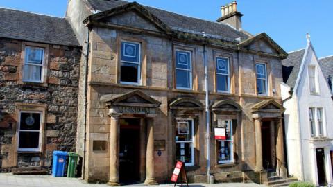 A picture of the West Highland Museum, which is two storey Victorian building. It has large windows and Doric portico doorways. 