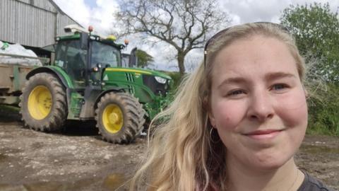 woman in front of tractor